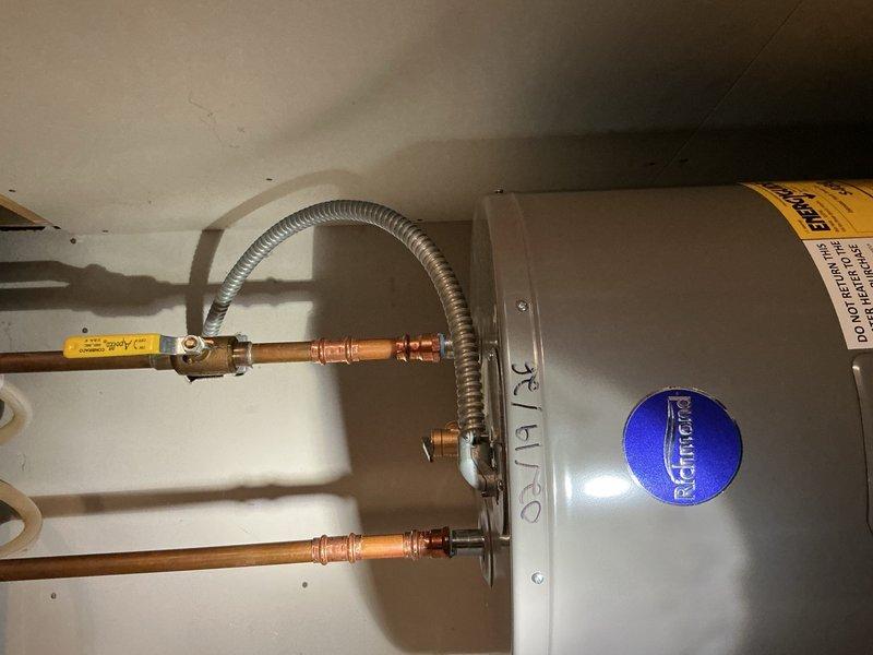 Completed annual plumbing inspection on one side of duplex unit. Identified and tightened loose packing on exterior faucet and secured loose handle on vanity faucet. Inspected water heater installation with copper supply lines and brass fittings, and verified shower fixture operation—all systems found to be in good working condition.