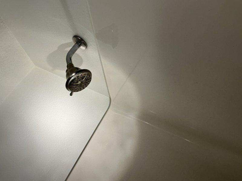 Completed annual plumbing inspection on one side of duplex unit. Identified and tightened loose packing on exterior faucet and secured loose handle on vanity faucet. Inspected water heater installation with copper supply lines and brass fittings, and verified shower fixture operation—all systems found to be in good working condition.