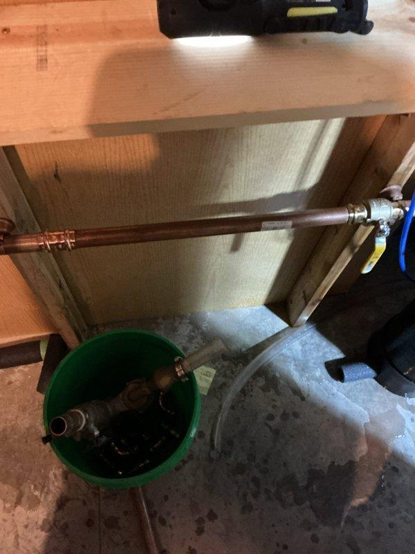 Responded to service call for failing reduced pressure (RP) backflow prevention device located in interior crawl space. Upon inspection, determined the existing RP assembly was obsolete with no replacement parts available from manufacturer. Removed the outdated interior backflow device and associated copper piping connections from beneath floor joists in crawl space. 

Installed new atmospheric vacuum breaker on exterior foundation wall for irrigation system protection, positioning unit a minimum of one foot above the highest sprinkhead elevation per code requirements. Configured new backflow assembly with proper copper piping connections, shutoff valves, and pressure gauge. Secured all exterior piping and equipment to foundation wall with appropriate mounting brackets. Tested vacuum breaker operation to ensure proper functionality and compliance with backflow prevention standards for irrigation system applications.