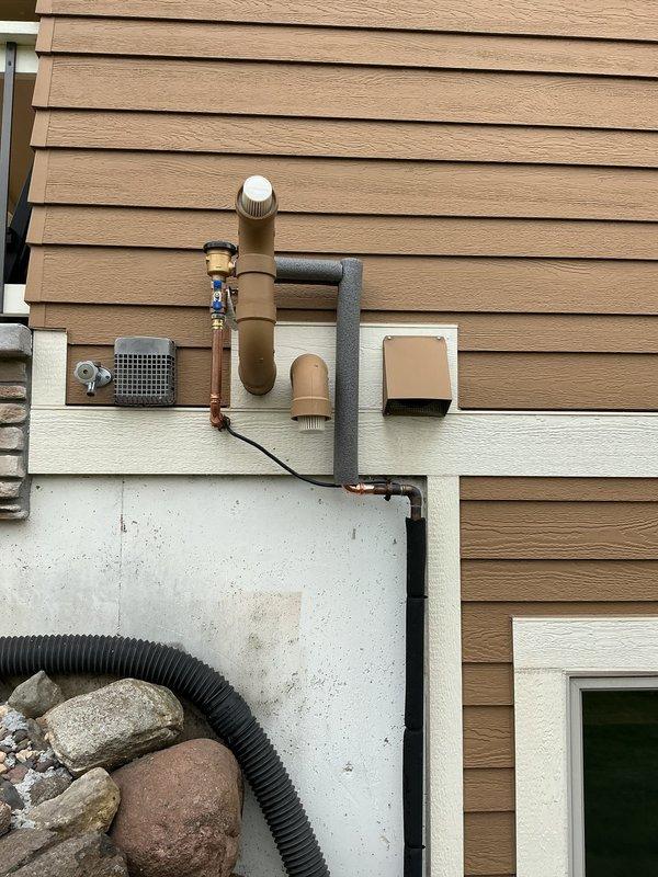 Responded to service call for failing reduced pressure (RP) backflow prevention device located in interior crawl space. Upon inspection, determined the existing RP assembly was obsolete with no replacement parts available from manufacturer. Removed the outdated interior backflow device and associated copper piping connections from beneath floor joists in crawl space. 

Installed new atmospheric vacuum breaker on exterior foundation wall for irrigation system protection, positioning unit a minimum of one foot above the highest sprinkhead elevation per code requirements. Configured new backflow assembly with proper copper piping connections, shutoff valves, and pressure gauge. Secured all exterior piping and equipment to foundation wall with appropriate mounting brackets. Tested vacuum breaker operation to ensure proper functionality and compliance with backflow prevention standards for irrigation system applications.