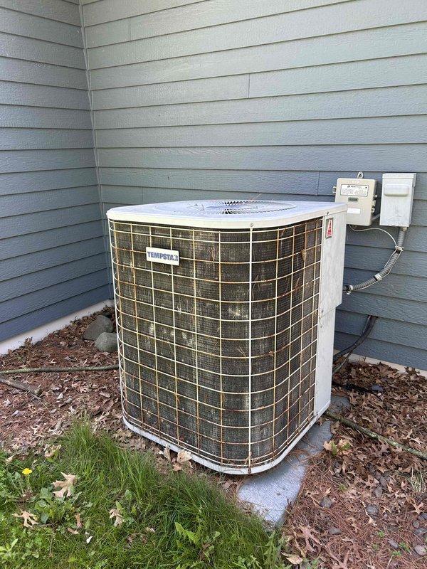 Performed comprehensive AC tune-up on 30-year-old Tempstar R-22 system. Inspected outdoor unit components, rinsed condenser coil, verified blower wheel and evaporator coil cleanliness, and confirmed clean filter. During operational testing, discovered suction line freezing with low pressure reading of approximately 45 PSI, indicating significant refrigerant undercharge from previous service by another company. Scheduled service advisor for follow-up refrigerant evaluation and system diagnostics to address the R-22 charging issue.