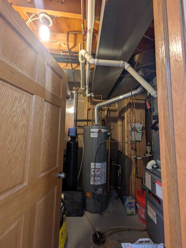 Responded to water leak in boiler room where a shut-off valve on overhead piping near the water heater was actively leaking. Replaced the defective valve and restored proper function to the plumbing system. Documented the mechanical room configuration and repaired plumbing infrastructure with photos for service records.