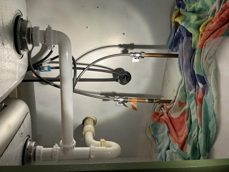 Responded to kitchen sink leak caused by improper supply line adapter installation. Removed faulty connections and installed two new compression straight stops to provide proper shut-off capability where none previously existed. Tested all connections and verified system is leak-free and functioning properly.