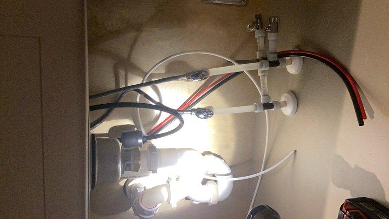 Completed comprehensive kitchen plumbing installation including customer-supplied kitchen faucet, sink basket, and drain connections. Ran refrigerator water supply line through cabinetry and installed shutoff valves for reverse osmosis system, kitchen faucet, and dishwasher. Flared gas line connection to fireplace and performed leak detection testing to verify system integrity, with all connections confirmed secure and operational.