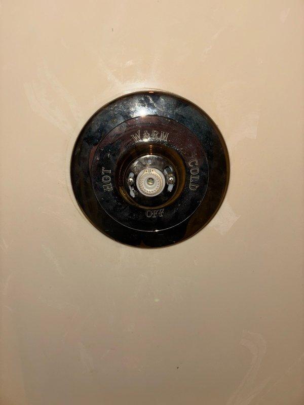 Responded to shower fixture repair call and attempted to reinstall the existing Kohler handle, but discovered the plastic retention piece that secures the handle to the valve stem had broken off and was beyond repair. Removed all existing trim components to expose the valve body and identified the unit as a Kohler Tempress II valve. Documented the valve model with photographs and provided reference images to facilitate sourcing of compatible replacement trim kit in chrome or brushed nickel finish, as color matching is not a priority for the customer.