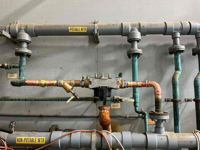 Replaced existing 2-inch reduced pressure zone (RPZ) backflow prevention assembly with new unit, including all necessary fittings and materials. Installation was coordinated during a scheduled water shutdown to minimize service disruption. The new backflow preventer was installed on the potable water system, properly mounted and secured to the wall structure, and integrated with the existing copper and PVC piping configuration. Upon completion, the assembly was tested and certified in accordance with state registration requirements to ensure proper operation and compliance with backflow prevention standards.