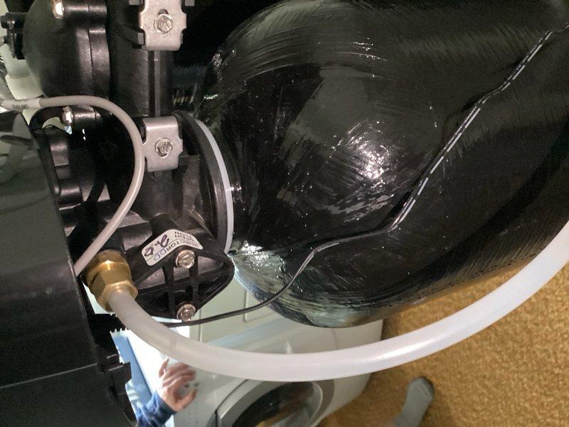 Responded to callback for water softener leak causing carpet saturation near unit installed in January. Upon inspection, identified leak originating from failed gasket on right side of softener head. Documented condition with photographs and ordered replacement parts for repair completion.
