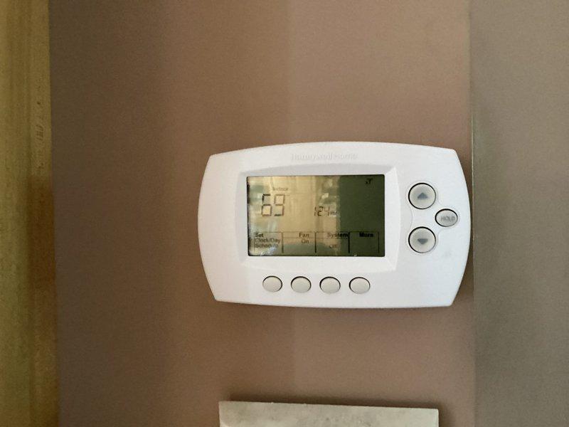 Completed annual AC tuneup and maintenance inspection on residential cooling system. Upon arrival, found outdoor condenser coil heavily soiled with dirt, dust, and debris accumulation affecting airflow and system efficiency. Cleaned condenser coil, inspected fan operation, and verified thermostat functionality showing proper temperature control at 69 degrees. All system components operating within normal parameters following maintenance service.