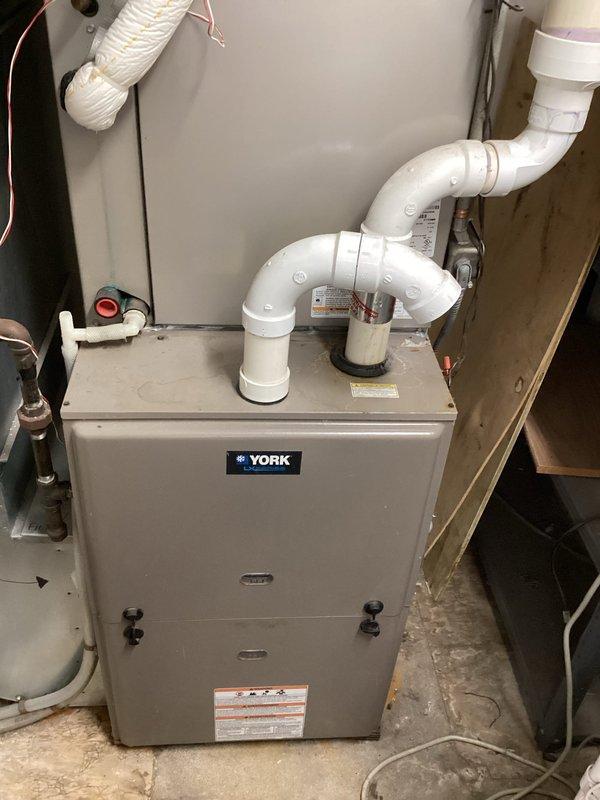 Completed comprehensive AC tune-up and maintenance service on a 6-year-old residential HVAC system located in a commercial property. Performed full system inspection including the York furnace with 10-12 year old air handler unit. Identified and replaced faulty door safety switch to restore proper system operation. Utilized infrared thermometer to verify temperature differentials and system performance. Inspected condensate drain system, PVC venting configuration, and all mechanical components to ensure optimal functionality and safety compliance.