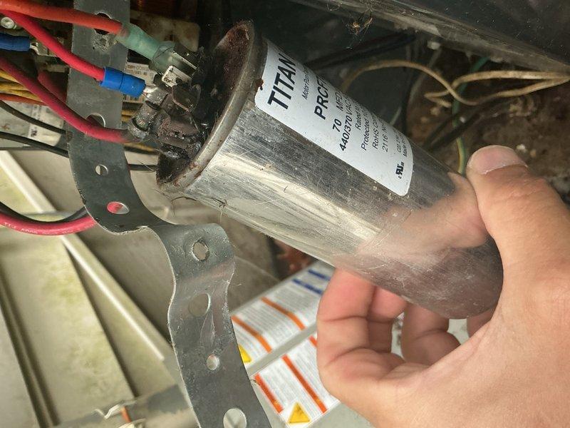 Performed seasonal air conditioning tune-up on residential system of undetermined age. During inspection, discovered the outdoor unit capacitor connections had melted down, creating a safety hazard and preventing proper system operation. Identified significant debris accumulation including organic material and evidence of rodent activity within the outdoor unit cabinet. Documented the failed capacitor with photographs showing heat damage and deteriorated connections on the TITAN HD component. Informed customer of the necessary capacitor replacement and provided estimate for parts and labor to complete the repair.