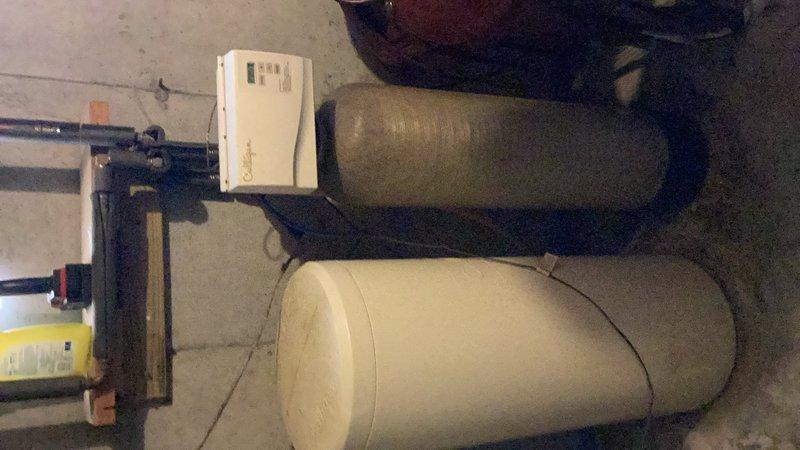 Responded to water softener leak caused by hole in brine tank. Inspected dual-tank water treatment system and identified compromised brine tank requiring replacement. Documented existing installation with photos and provided estimate for new water softener unit.