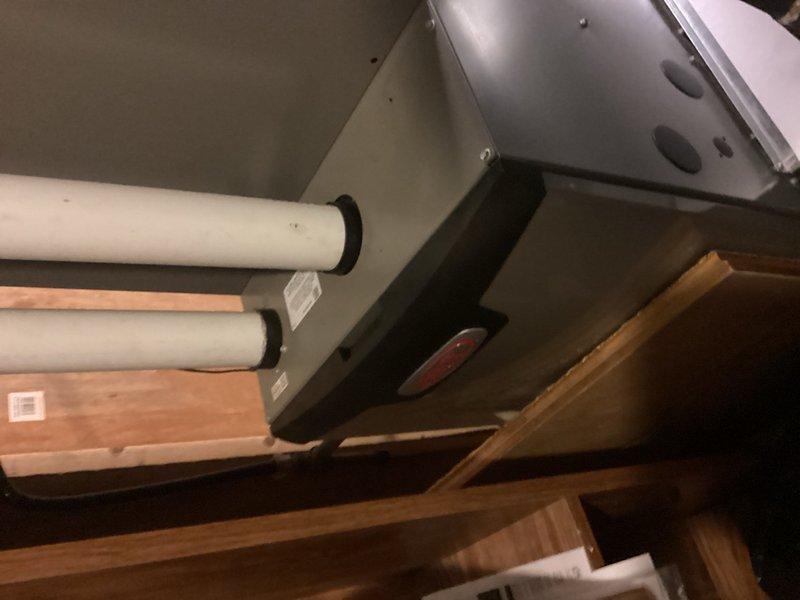 Responded to no hot water complaint for residential property with new infant. Upon inspection, found 19-year-old Richmond brand tanked water heater installed in utility area. Unit had exceeded typical service life expectancy and was no longer producing hot water. Assessed burner assembly and overall system condition. Provided estimate for burner cleaning service as well as complete water heater replacement options given the advanced age of existing equipment. Documented current installation configuration including copper supply piping, gas valve assembly, and drain pan placement for replacement planning purposes.