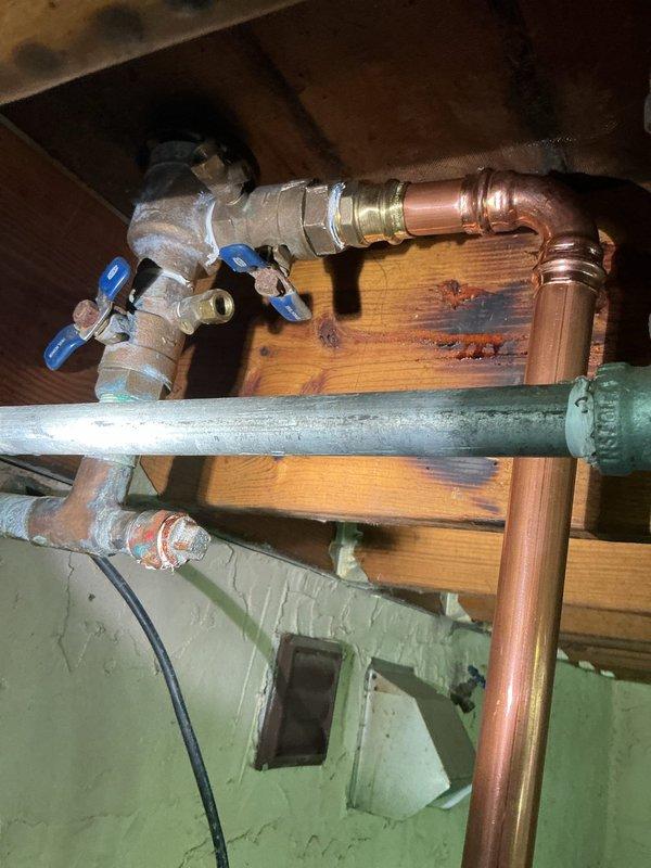 Supplied and installed 6 feet of copper waterline connecting to existing pressure vacuum breaker (PVB) and extended new line to existing underground irrigation system. Installed brass valve assembly with dual ball valves for shutoff control, utilizing soldered copper fittings and threaded brass adapters throughout the installation. Mounted plumbing assembly to wooden structural beams in basement area, ensuring proper support and alignment of all piping. Activated water supply to PVB and pressure tested all new fittings and connections to verify system integrity and confirm no leaks were present. All plumbing work completed in accordance with Minnesota Plumbing Code requirements. Installation includes one-year warranty coverage on all labor and parts.