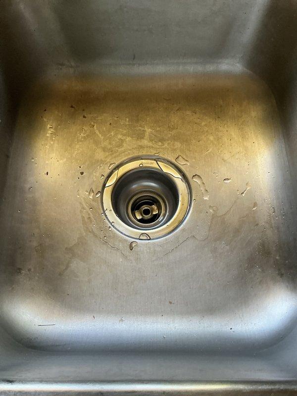 Responded to service call for kitchen sink basket strainer inspection. Upon arrival, found existing strainer showing signs of wear with visible mineral deposits and discoloration around the drain assembly. Removed old basket strainer from sink basin and installed new replacement unit, ensuring proper seal and secure fit to prevent future leaks.