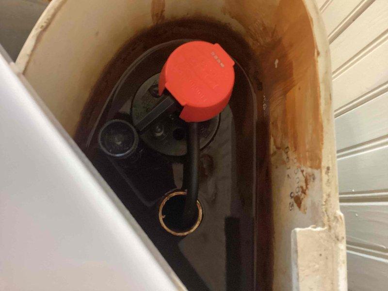 Replaced a failing standard diameter flush valve assembly and toilet fill valve. The existing flush mechanism showed signs of deterioration and mineral buildup throughout the tank interior. Removed the old flush valve components and installed a new standard diameter flush valve with fresh gaskets to restore proper flushing operation. Additionally replaced the fill valve to ensure reliable tank refilling. Tank interior displayed significant mineral deposits and age-related staining on porcelain surfaces. All components tested and verified operational upon completion.