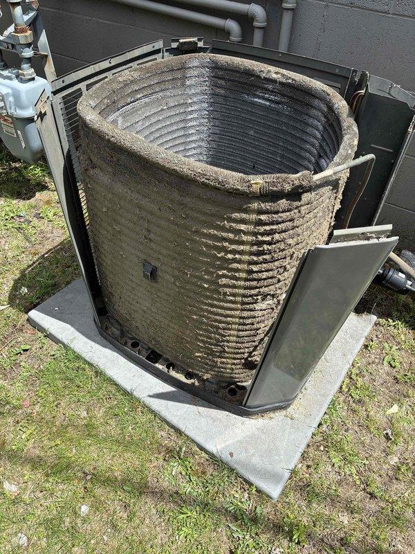 Responded to no cooling complaint at commercial property with two separate AC systems. First unit (1418 side): Found older R22 Goodman system with locked condenser fan motor and severely damaged fan blade; unit inoperable and requires replacement. Second unit (1416 side): Trane AC system not running due to loss of 24V power at furnace; discovered tripped rollout switch caused by cracked heat exchanger. Reset rollout to restore AC operation temporarily. Found condenser coil heavily plugged with debris, restricting airflow. Performed complete coil cleaning on Trane unit per customer approval, restored system to proper operation with 21-degree temperature differential across evaporator coil. Furnace tagged out due to failed heat exchanger presenting safety hazard; recommended immediate furnace replacement. Advised customer that R22 system requires full AC replacement due to failed motor and refrigerant phase-out. Provided estimates for all necessary repairs and replacements; awaiting buil