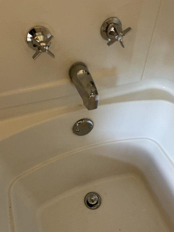 Responded to a leaking shower valve within the wall cavity. Removed the existing failed valve assembly and installed a new two-handle tub and shower valve with chrome trim, including cross-handle controls and tub spout with diverter. Replaced the bathtub drain strainer and overflow cover plate to complete the fixture upgrade. All components installed to manufacturer specifications with a one-year warranty on parts and labor.