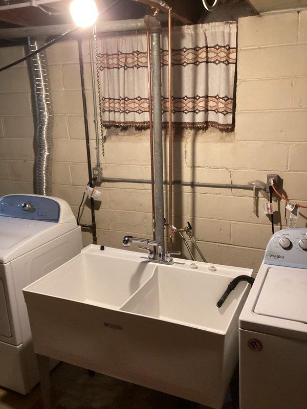 Completed comprehensive residential water line repipe including installation of new copper supply lines throughout the home. Work encompassed seven fixture locations: outside hose bibb, double laundry tub with deck-mount faucet and hot/cold washer connections, kitchen sink with dedicated shut-offs for dishwasher and ice maker, full bathroom rough-in for toilet, lavatory sink, and tub/shower valve with new single-handle chrome trim kit featuring multi-function handheld showerhead and slide bar, water heater supply and return connections, and main shut-off valve installation downstream of the water meter. All plumbing connections tested and verified operational with no leaks detected.