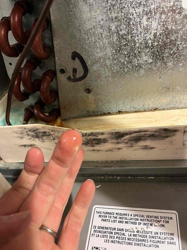 Responded to no cooling complaint on system with thermostat installed in November. Verified thermostat settings and provided operational instruction on basic functions. Diagnosed system tripped on low pressure safety due to complete refrigerant loss from leaking evaporator coil. Documented conditions with photos showing mold growth on wooden trim and corroded metal surfaces indicating moisture issues related to the failing coil. Prepared estimate for evaporator coil replacement to restore system operation.