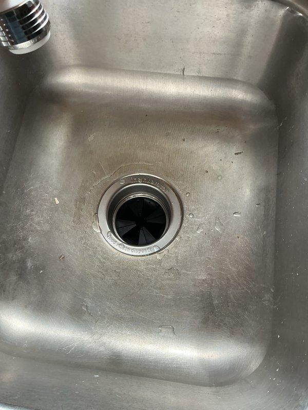Responded to kitchen sink drainage issue caused by failed garbage disposal unit. Upon inspection, found 20-year-old disposal had ceased operation after attempting to grind potato skins. Removed old disposal unit and installed new garbage disposal, restoring full functionality to kitchen sink drain system. Verified proper operation and drainage upon completion.
