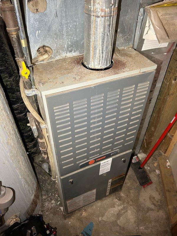 Responded to a no-cooling complaint on a 10+ year old air conditioning system that had been running continuously for 9 hours. Upon arrival, performed comprehensive inspection of the evaporator coil and heat exchanger, finding no major cracks or damage, though minor spotting was noted on both interior and exterior surfaces of the heat exchanger. Proceeded to outdoor condenser unit and discovered absence of 240V power supply. Traced electrical issue to indoor breaker which was found in the off position. After restoring power to the system, conducted diagnostic testing and identified a failed run capacitor as the root cause of the malfunction. Replaced the defective capacitor with new component and verified compressor operation. Confirmed system cooling performance with refrigerant pressure readings now within manufacturer specifications and proper operating range. Unit restored to normal cooling operation.