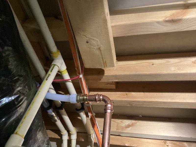 Responded to call for water heater leaking from bottom with intermittent hot water issues. Upon inspection, determined the leak was not originating from the water heater unit itself, but from failed CPVC piping located above the water heater in the joist cavity. Replaced the defective CPVC section with new piping and fittings to restore proper system integrity and eliminate the leak.