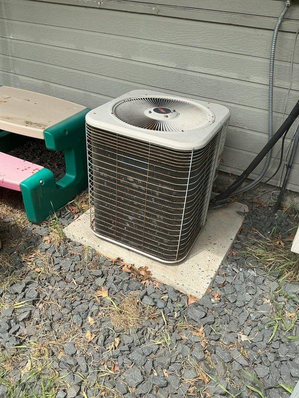 Responded to no cooling call on 23-year-old Goodman air conditioning system. Found frozen refrigerant lines at outdoor condenser unit and confirmed system was low on R22 refrigerant. Advised customer that R22 is no longer stocked due to phase-out regulations and recommended contacting a service provider who still services legacy refrigerant systems. System was shut down to prevent compressor damage from continued operation while frozen. Documented equipment condition with photos of outdoor condenser unit and indoor furnace components.
