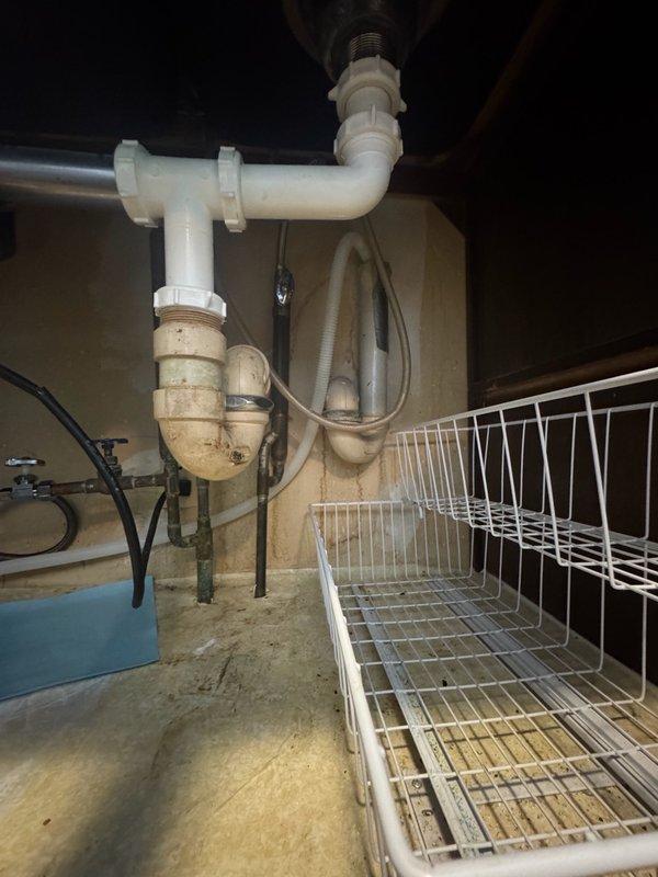 Removed existing dishwasher and installed new customer-supplied unit. Replaced section of copper piping to accommodate new angle stop valve for refrigerator water line. Installed new refrigerator supply line to ensure proper connection and water flow. Updated plumbing connections beneath kitchen sink area to meet current code requirements and integrate new appliance configuration with existing drain assembly and water supply system.