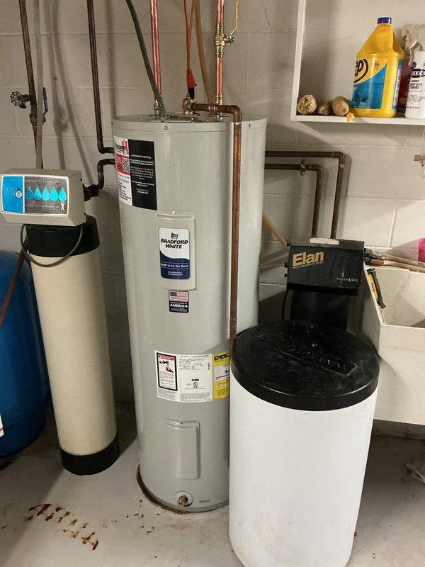 Responded to service call for leaking water heater in residential basement utility area. Upon arrival, confirmed existing water heater was actively leaking and required immediate replacement. Successfully removed old unit and installed new Bradford White 50-gallon electric water heater. Connected all copper supply and discharge piping to existing plumbing infrastructure, ensuring proper integration with adjacent water softener and Elan water treatment system. Installed appropriate shut-off valves and verified all connections for proper seal and operation. Tested new water heater for functionality, confirmed no leaks at any connection points, and restored hot water service to residence.