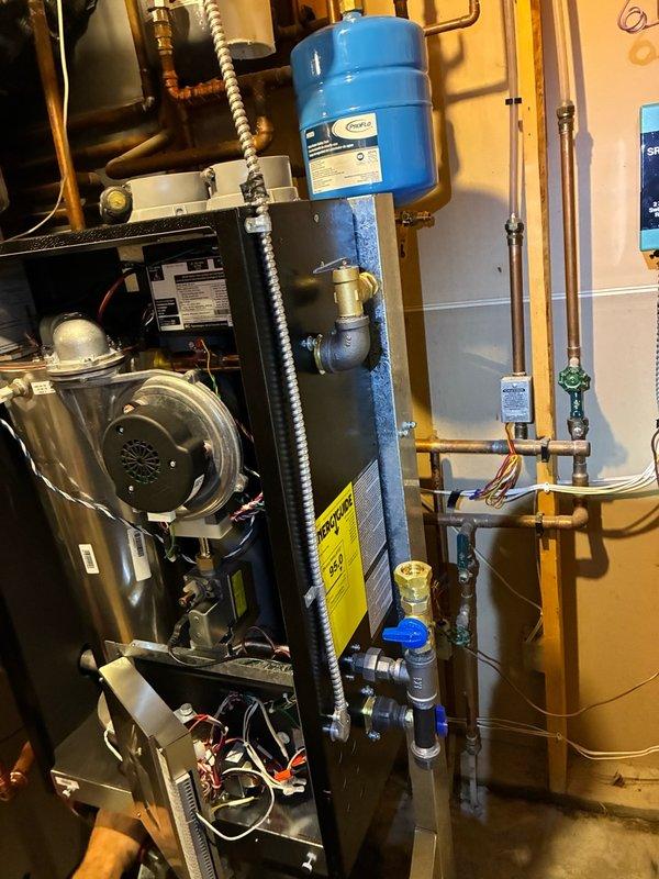 Completed replacement of existing boiler with IBC SL Series 95% AFUE modulating boiler (14K-115K BTU capacity). Removed and replaced two expansion tanks as identified during site assessment. Installed new recirculating pump on NTI side arm to improve system performance. Retained all existing communication wiring, zoning controls, and control boards to maintain system functionality. Performed extensive electrical modifications including rerouting power supply wire to new boiler location, wiring boiler unit, installing junction box for line supply, and establishing proper grounding means per code requirements. Completed all copper piping connections and soldering to integrate new equipment with existing hydronic heating system. System tested and passed final electrical inspection.