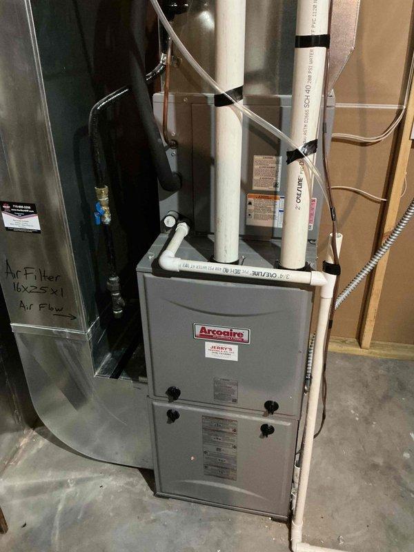 Performed comprehensive annual maintenance on 5-year-old Arcoaire HVAC system including outdoor condenser unit and indoor furnace. Cleaned outdoor condenser coils and fins, removed debris from unit perimeter, inspected electrical connections at disconnect box, and verified proper conduit routing. Tested all system components including compressor operation, fan motor function, refrigerant pressures, and electrical controls. Verified indoor furnace operation, checked air filter specifications (16x25x1), inspected PVC condensate drainage lines, and tested safety controls. All equipment operating within manufacturer specifications with no issues identified.