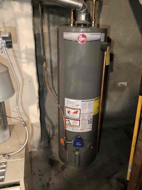 Completed biannual plumbing inspection including comprehensive evaluation of water heater, water softener, sump pump, laundry hoses, and exterior faucets. Inspected Rheem Professional water heater for proper operation, checked all connections, copper piping, and control valves, noting minor moisture present at base of unit on concrete floor. Performed leak detection throughout plumbing system and verified all components functioning within normal parameters.