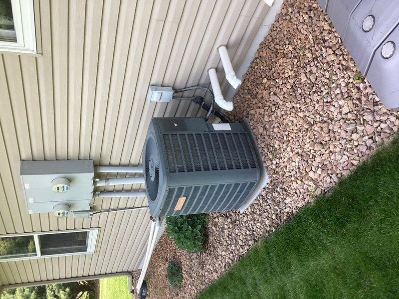 Performed annual AC tune-up per rewards membership on an 18-year-old single system. Customer reported inadequate cooling performance. Upon inspection, found no temperature drop across the evaporator coil. Connected manifold gauges and discovered system was in a vacuum, indicating complete loss of refrigerant charge. Identified unit uses R-22 refrigerant, which is no longer stocked or serviced. Explained situation to customer and provided recommendation for new equipment replacement due to age of system and refrigerant phase-out. Documented existing indoor furnace unit and outdoor condenser installation with photos for equipment replacement quote.