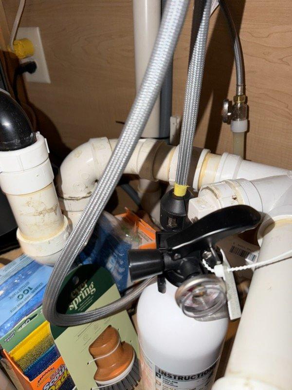 Completed kitchen sink installation following new countertop installation. Installed new faucet, garbage disposal unit, and complete drain assembly with P-trap configuration using PVC piping. Reconnected water supply lines to existing plumbing infrastructure and ensured all connections were secure and leak-free.