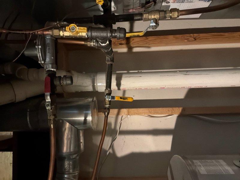 Responded to service call for leaking Bradford White water heater. Verified unit serial number YJ50335163 and confirmed active 6-year parts and tank warranty coverage. Performed visual inspection of water heater installation, including copper supply lines with yellow-handled ball valves, black iron gas piping with brass fittings, and surrounding plumbing connections in basement utility area. Documented leak condition and overall system configuration with photographs. Assessed that unit requires replacement due to tank failure. Prepared estimate for water heater replacement under warranty terms, with customer understanding that labor costs apply separately from covered parts.