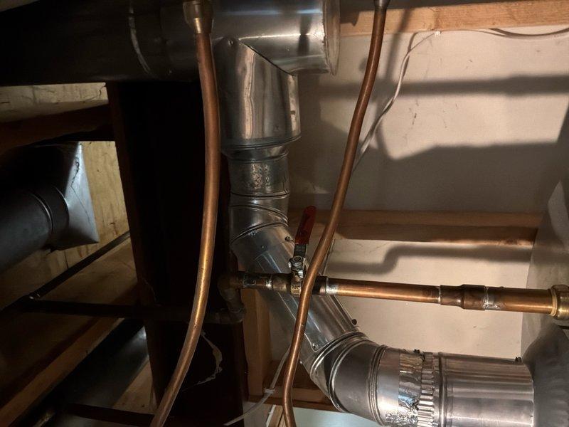 Responded to service call for leaking Bradford White water heater. Verified unit serial number YJ50335163 and confirmed active 6-year parts and tank warranty coverage. Performed visual inspection of water heater installation, including copper supply lines with yellow-handled ball valves, black iron gas piping with brass fittings, and surrounding plumbing connections in basement utility area. Documented leak condition and overall system configuration with photographs. Assessed that unit requires replacement due to tank failure. Prepared estimate for water heater replacement under warranty terms, with customer understanding that labor costs apply separately from covered parts.