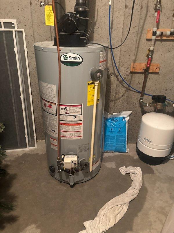 Responded to report of water leakage in basement utility area near a 10-year-old AO Smith 50-gallon gas power vent water heater. Conducted thorough inspection to determine leak source, as water softener equipment was also present in the immediate vicinity. Confirmed water heater was actively leaking from the base of the unit, indicating internal tank failure. Documented conditions with photographs showing the existing installation, including power vent assembly, copper piping connections, and current venting configuration. Identified that existing PVC venting was installed with cell core PVC, which does not meet current code requirements for power vent water heater applications. Informed homeowner of findings and recommended complete water heater replacement due to tank failure. Prepared detailed estimate for like-for-like replacement with comparable short 50-gallon power vent unit to maintain existing footprint and clearances in basement mechanical room. Estimate included dielectric u