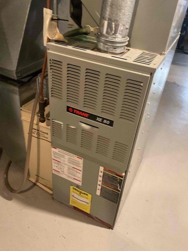 Responded to no cooling call on aging Trane XE 80 system with frozen refrigerant lines. Upon arrival, confirmed unit was shut down due to ice buildup on suction line. Diagnosed system as low on R-22 refrigerant. Allowed coil to thaw completely, then recharged system to manufacturer specifications and verified proper operation of both indoor and outdoor units before departure.
