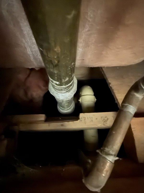 Responded to report of bathtub drain leaking through ceiling. Upon arrival, performed diagnostic testing by running water through tub drain assembly—no leakage detected at drain connection. Conducted systematic water testing at tub spout, overflow assembly, and shower valve trim. Testing revealed water infiltration occurring at back side of shower wall, indicating compromised seal at fixture penetrations. Applied silicone sealant around all tub trim components and along back side of shower wall to prevent further water intrusion. Documented conditions with photographs of shower assembly and accessible plumbing connections in ceiling space below.