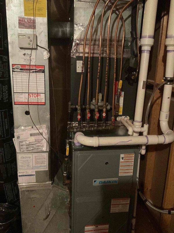 Performed comprehensive AC tune-up on 7-year-old Daikin split system. Inspected indoor furnace unit and outdoor condensing unit, verified proper operation of all components including copper refrigerant lines, manifold connections, and red-handled service valves. Checked electrical connections at outdoor disconnect, confirmed adequate airflow through condenser coils and fan assembly, and verified system is operating within manufacturer specifications. System found to be functioning properly with no issues identified during maintenance inspection.
