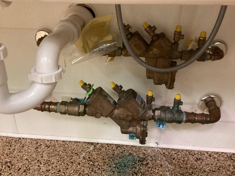 Responded to service call for RPZ backflow preventer that had been leaking for seven months. Performed thorough inspection of the commercial backflow prevention assembly and confirmed active leak. Assessed condition of all components including valves, test cocks, and check assemblies. Determined that unit requires complete rebuild with replacement parts rather than simple repair. Documented existing plumbing configuration with multiple bronze valves, flexible supply connections, and associated piping. Provided estimate for rebuild service including necessary replacement parts and labor to restore proper function and prevent continued water loss.