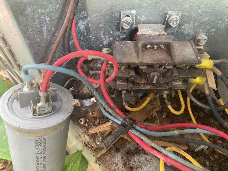 Responded to no cooling call on 30-year-old central air conditioning system. Upon inspection, discovered extensive rodent damage to outdoor condensing unit with significant debris accumulation including nesting materials, leaves, and organic matter throughout electrical compartment. Rodent activity caused failure of run capacitor and multiple fuses. Electrical components showed severe corrosion and deterioration consistent with age and environmental exposure. Terminal block and contactor assembly exhibited heavy rust and oxidation. 

Given the system's age of three decades—well beyond typical 15-20 year service life expectancy—and extent of damage to multiple electrical components, presented customer with options to either replace failed parts or consider full system replacement. Documented conditions with photographs showing corroded electrical connections, damaged capacitor, compromised wiring, and contaminated cabinet interior. Advised customer that while immediate repairs could res