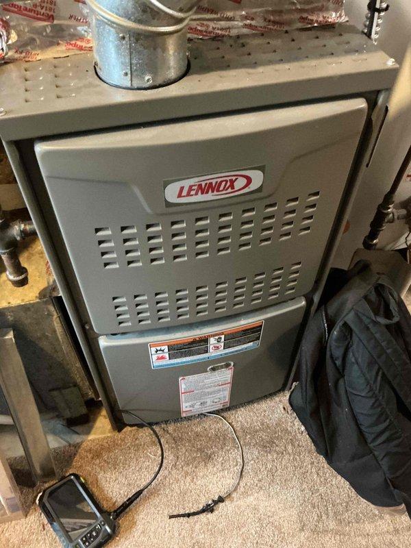 Responded to no cooling complaint on 7-year-old Goodman air conditioning system. Upon arrival, found warm air discharge from supply vents. Discovered evaporator coil frozen solid. Thawed coil and performed system diagnostics, revealing refrigerant charge 2-3 pounds low, indicating active leak in system. Visual inspection identified oily residue on refrigerant lineset near furnace connection point, though exact leak source could not be definitively determined without further testing. Recommended recharging system with refrigerant, injecting UV dye, and scheduling follow-up visit to pinpoint leak location under operating conditions. Provided repair estimates and system replacement options for consideration.