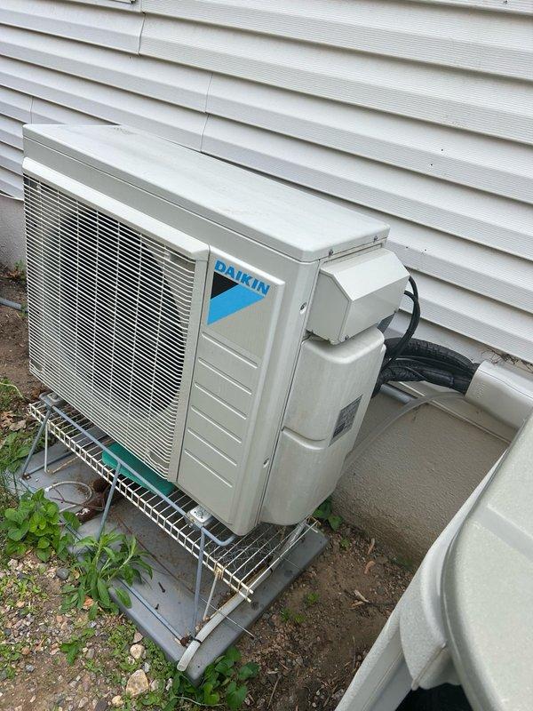 Responded to a no cool call on a 4-year-old Daikin mini split system experiencing intermittent cooling failure and error code blinking after approximately 3 hours of operation in any mode. Upon arrival, confirmed system was blowing warm air and discussed history of previous reinstallation due to poor original installation and subsequent line relocation. Investigated reported issue where all indoor heads synchronize modes and system requires circuit breaker reset to temporarily clear error codes, though results remain inconsistent. Inspected outdoor condenser unit and indoor wall-mounted head unit, checking filters which were found clean per homeowner maintenance. Evaluated system for potential causes including refrigerant issues, communication errors between heads and condenser, and electronic control board malfunctions. Noted one head unit is currently out of service due to damage and system uses discontinued refrigerant, making replacement parts unavailable. Performed diagnostic test