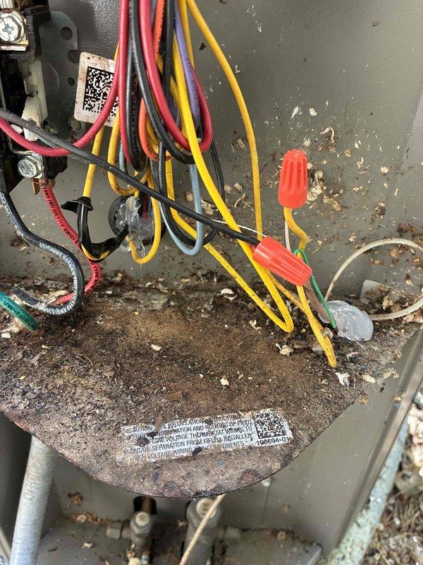 Responded to no cooling complaint on 5-year-old Bryant air conditioning system. Upon inspection, found condenser unit not operating due to rodent damage in electrical compartment. Discovered mouse nest inside condenser housing with chewed low voltage control wiring preventing system operation. Removed rodent nest and debris from electrical compartment. Repaired damaged low voltage wiring by splicing and insulating affected conductors. Sealed entry points with silicone to prevent future rodent intrusion. Tested system operation and confirmed proper cooling function with 19-degree temperature differential across evaporator coil. Installed customer-provided air filter to complete service call.