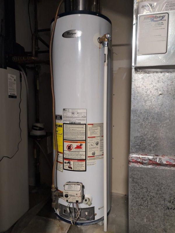 Responded to no hot water complaint at residential property. Upon arrival, found existing Whirlpool N40T61-343 water heater had ceased producing hot water despite pilot light remaining lit. After assessment, determined the unit had reached end of service life and was not economical to repair. Removed and properly disposed of old 40-gallon tanked water heater. Installed new 40-gallon gas-fired residential water heater in basement mechanical room. Connected copper supply lines via soldered connections to match existing plumbing configuration without threaded unions. Installed new temperature and pressure relief valve with proper discharge piping. Connected gas supply line and flue venting to manufacturer specifications. Tested all connections for leaks, verified proper combustion and venting operation, and confirmed hot water delivery to fixtures throughout home. Unit left in full operational condition.