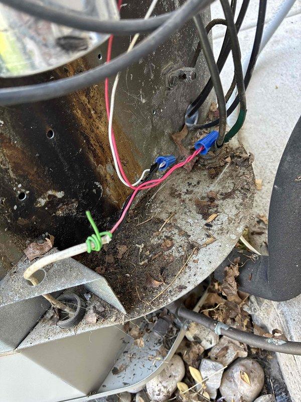 Responded to no cool call on 10+ year old 3-ton R22 system. Indoor blower operational but outdoor unit not receiving signal. Upon inspection, discovered extensive mouse nest in condenser unit blocking electrical cabinet. Removed rodent debris and inspected wiring—fortunately no wire damage occurred, though electrical cabinet showed evidence of previous burn damage and rewiring from past rodent issues. After clearing nest and testing, compressor failed to start. Diagnosed failed run capacitor on hermetic terminal. Replaced capacitor and verified compressor operation. Connected manifold gauges to check R22 charge levels—system pressures within acceptable range with 21-degree temperature drop across evaporator coil. Blower airflow slightly below optimal 1200 CFM for tonnage but within operational parameters given acceptable pressures and temperature differential. Confirmed system cooling properly and advised homeowner regarding R22 refrigerant phase-out and future service considerations f