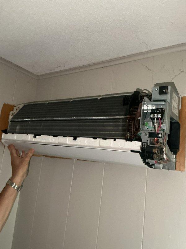 Provided second opinion estimate for 9-year-old Fujitsu Halcyon multi-zone mini split system with three indoor head units. Inspected system after previous contractor diagnosed one head unit as damaged and requiring replacement. Evaluated outdoor condensing unit and indoor evaporator coils, noting significant dust and debris accumulation on accessible head unit's finned coil assembly. Assessed refrigerant line connections and electrical components at both outdoor unit and indoor heads. Prepared estimate for system evacuation, refrigerant recovery, isolation of damaged third head unit, system recharge with approximately 4 pounds of refrigerant, and restoration of cooling operation to remaining two functional head units. Provided separate pricing option for replacement of damaged head unit pending parts availability and sourcing. Documented equipment condition with photographs showing internal components of wall-mounted head unit and exterior condensing unit installation with refrigerant 