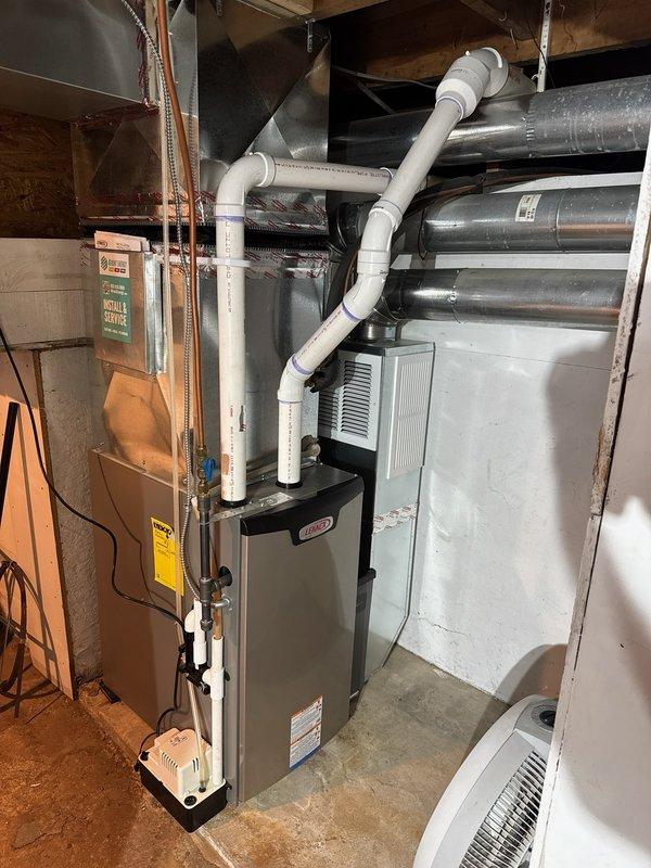Responded to no cooling complaint on 27-year-old residential air conditioning system. Found evaporator coil severely frozen with active refrigerant leak causing water damage to furnace below. System operating on obsolete R22 refrigerant and losing charge rapidly, freezing up almost immediately upon startup. Due to age of equipment, obsolete refrigerant type, active leak, and risk of continued water damage voiding furnace warranty, recommended full system replacement. Scheduled replacement estimate appointment and advised against further operation to prevent additional damage to furnace unit.