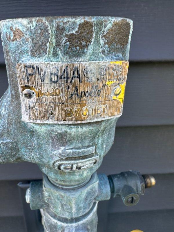 # Irrigation System Pressure Vacuum Breaker Repair

Responded to service call for malfunctioning irrigation system valve and identified leak at pressure vacuum breaker (PVB) assembly. Upon inspection, discovered that the PVB bonnet had been blown off during previous fall winterization process, causing the float mechanism to fail and preventing proper backflow prevention operation. The assembly exhibited significant corrosion and oxidation on galvanized fittings, with extensive verdigris buildup on brass components indicating prolonged exposure to outdoor elements.

Performed complete rebuild of pressure vacuum breaker assembly, replacing damaged bonnet, internal float mechanism, and associated seals. Replaced corroded valve components and fittings as necessary to restore proper function. Tested system operation by cycling irrigation valves to verify proper water flow and backflow prevention. Confirmed all zone valves operated correctly with no leaks present at connections or rebuilt as